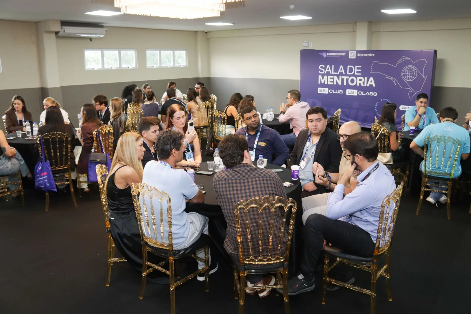 Sala de mentoria do ES Club com mesas de discussão